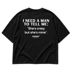 Back view of the black I NEED A MAN TO TELL ME: She’s crazy but she’s mine Oversized T-Shirt by MALVICE.