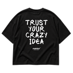 Back view of the black TRUST YOUR CRAZY IDEA Oversized T-Shirt by MALVICE, handwritten lettering.