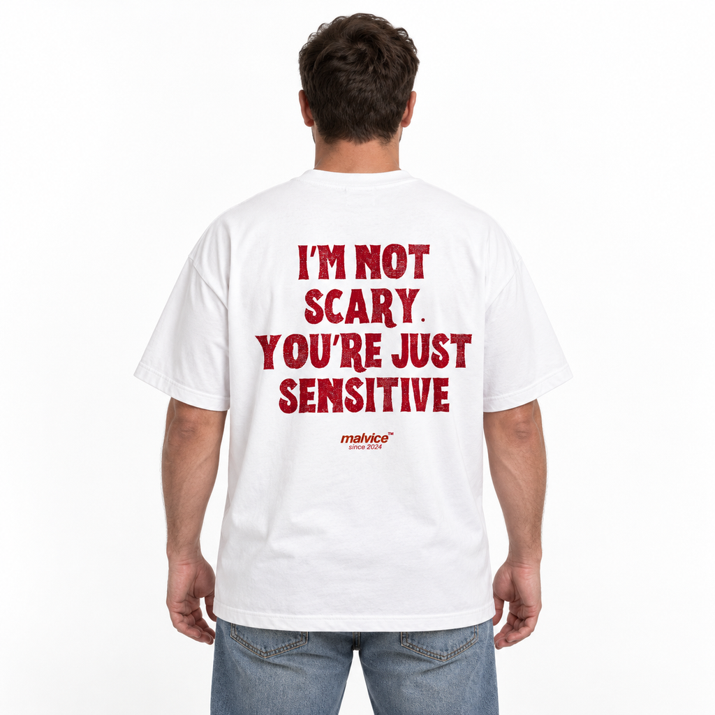 Model wearing the white I’M NOT SCARY. YOU’RE JUST SENSITIVE Oversized T-Shirt by MALVICE, back view.