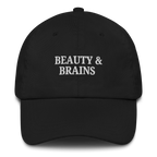 Black MALVICE adjustable dad hat with “BEAUTY & BRAINS” front embroidery