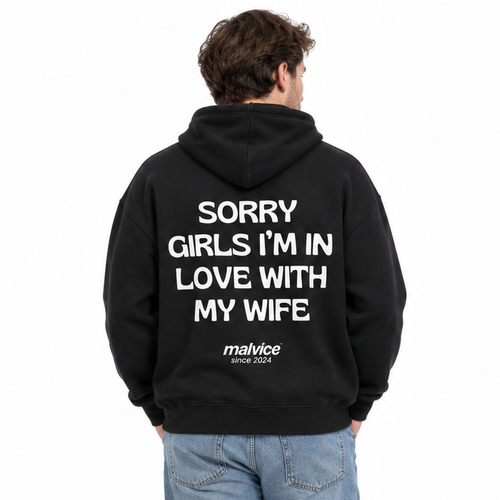 SORRY GIRLS I’M IN LOVE WITH MY WIFE Oversized Hoodie — black Hoodie on man model, white studio