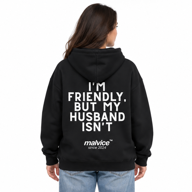 I'M FRIENDLY, BUT MY HUSBAND ISN'T Oversized Hoodie — black Hoodie on woman model, white studio