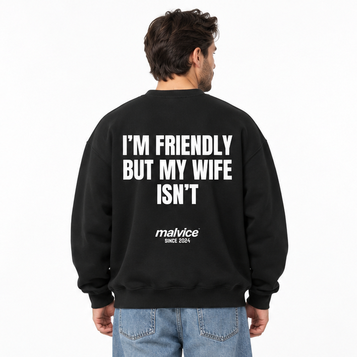 I’M FRIENDLY BUT MY WIFE ISN’T Oversized Sweatshirt — black Sweatshirt on man model, white studio