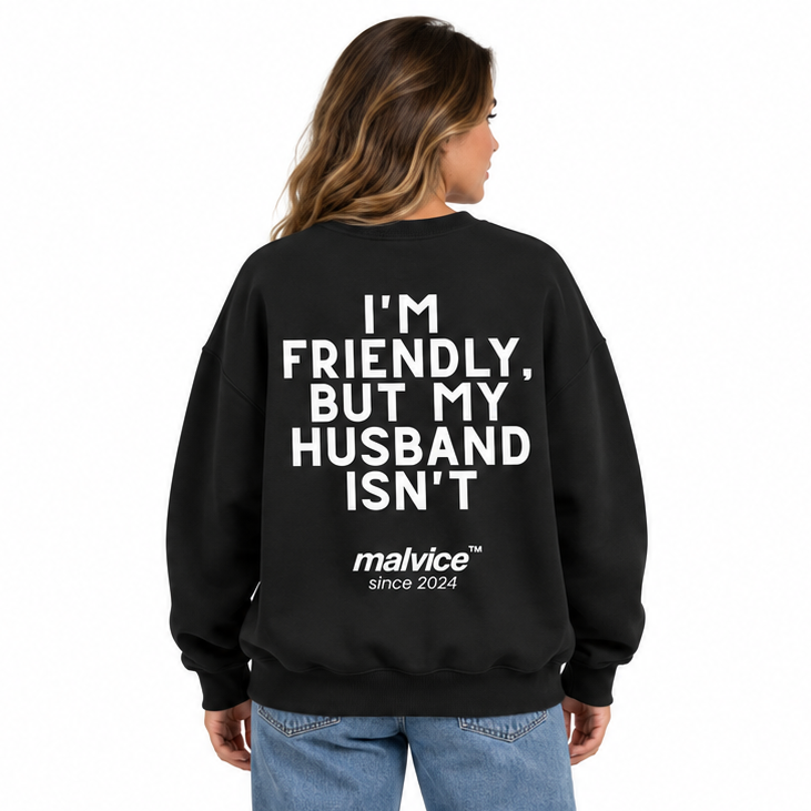 I'M FRIENDLY, BUT MY HUSBAND ISN'T Oversized Sweatshirt — black Sweatshirt on woman model, white studio