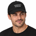 SOMEBODY'S PROBLEM Adjustable Dad Hat — black Cap on man model, white studio