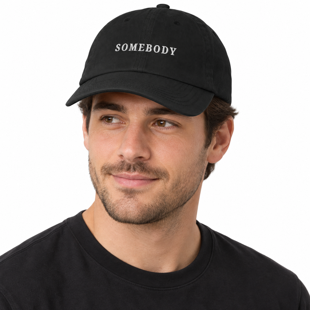 SOMEBODY Adjustable Dad Hat — black Cap on man model, white studio