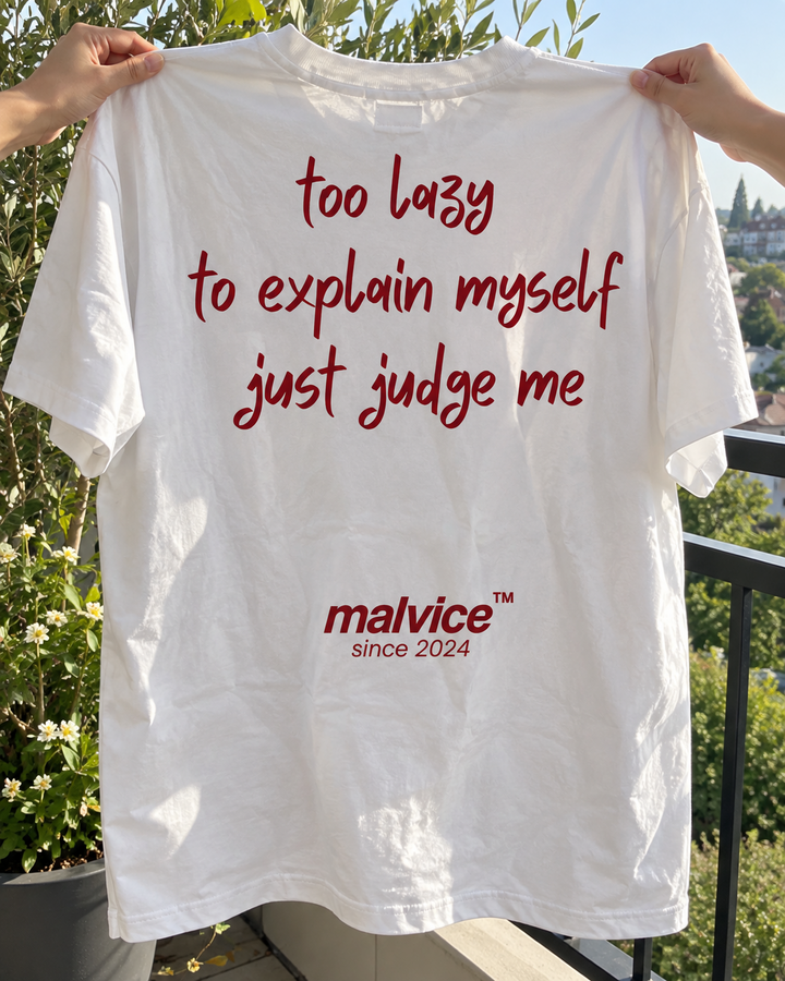 White MALVICE Too Lazy to Explain Myself Just Judge Me oversized T-shirt held outdoors